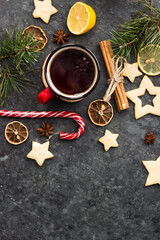hot tea in a red mug in a new year's atmosphere. Christmas morning. A mug with a drink next to Christmas tree branches, oranges, spices and cookies