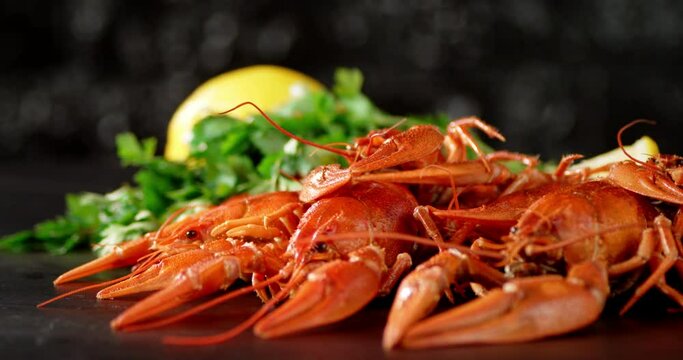 Boiled crayfish with herbs and lemon on the table rotate. 