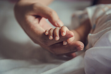 Newborn baby holding mother's hand. - Powered by Adobe