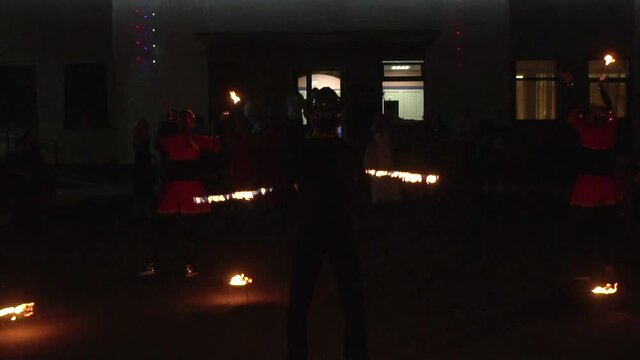 Man shows dangerous tricks with fire in fire show at night, background, slow mo