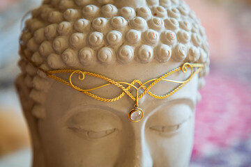 Brass tiara with gemstone on Buddha statue head © marbenzu