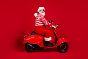 Fototapeta na wymiar Full length body size profile side view of his he handsome cheery overweight bearded Santa father riding moped road way rental service traveler isolated bright vivid shine vibrant red color background