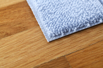 A bright blue foot mat rests on the parquet floor.