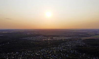 Beautiful top view of the forest landscape at sunset near the suburb
