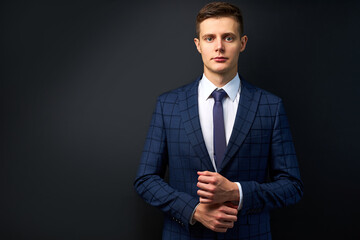 attractive caucasian man in formal stylish suit posing at camera isolated on black background, confident business person