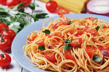 A plate with spaghetti with tomatoes