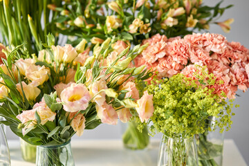 Many different colors on the stand or wooden table in the flower shop. Showcase. Background of mix of flowers. Beautiful flowers for catalog or online store.