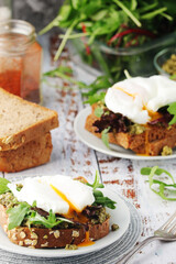 Homemade sandwiches with pesto, green salad and poached eggs
