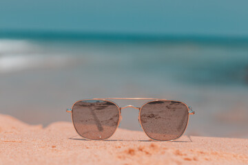 Sunglasses are lying on the sand on the beach of Ashdod, a background of blurred sea