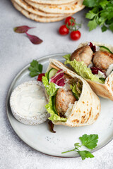 Meatballs in a pita with vegetable and yogurt sauce