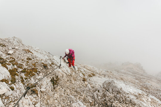 High angle view of woman climbing Alpspitze Mountain via Alpspitz Ferrata