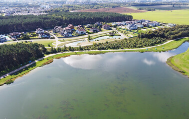 Top view of a beautiful city summer park with a lake and an embankment. 