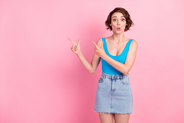 Unbelievable. Photo of charming cute excited young girl crazy look directing fingers empty space unexpected discount wear denim mini skirt blue singlet isolated pink color background