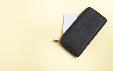 Womans wallet and card, on an isolated yellow background.