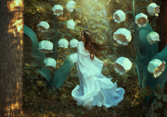 A beautiful girl elf walks in a fantasy forest. Huge flowers lilies of the valley, green trees,...