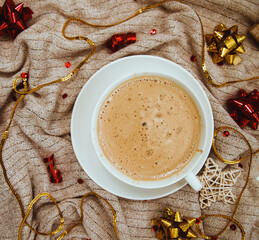 Coffee on a background of knitted fabric with gifts and holiday bows.Hot winter drink. Cocoa and cappuccino.