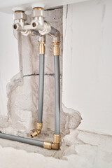 connection heating pipes to white Radiator in a new apartment under construction. Work As A Plumber, mounting water heating radiator on the white wall indoors