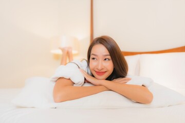 Portrait beautiful young asian woman smile relax on bed in bedroom interior