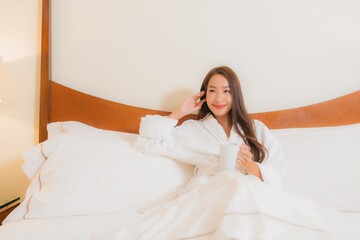 Portrait beautiful young asian woman smile relax on bed in bedroom interior