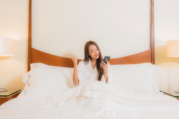 Portrait beautiful young asian woman use smart mobile phone on bed