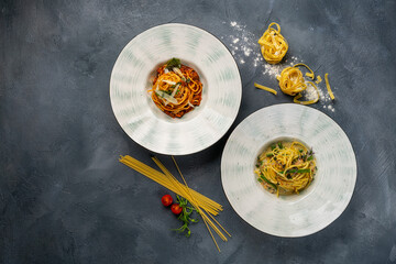 Two plates with tasty penne pasta on grey table