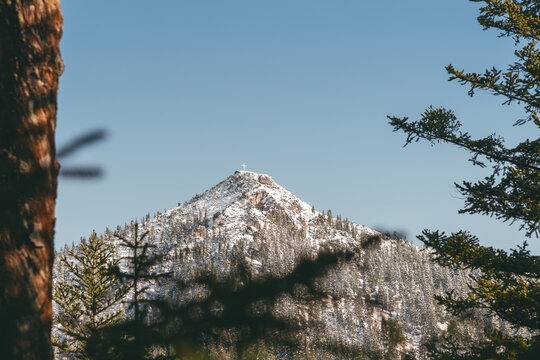 Low angle view of Mountain Herzogstand with cross against sky