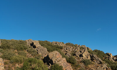Rock spine chain in the hillside under blue sky