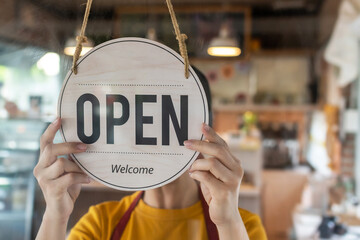 Restart. waitress woman wearing protection face mask turning Open sign board reopen after...