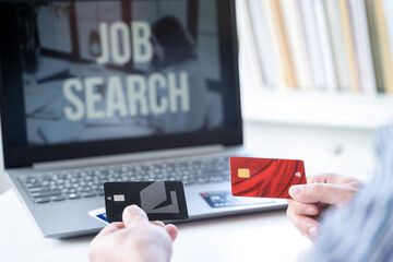 Zero balance, empty credit cards in hands. Remote job search in laptop. No money, unemployment, crisis, job loss. Looking for work at home. Hiring employees, freelancers for telework
