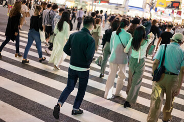 コロナ禍で渋谷スクランブル交差点を歩く若者たち後姿