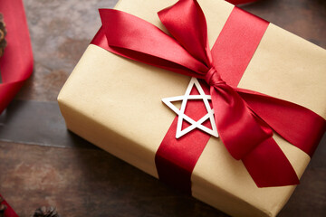 Weihnachtsgeschenk mit toter Schleife und Holzstern als Geschenkanhänger