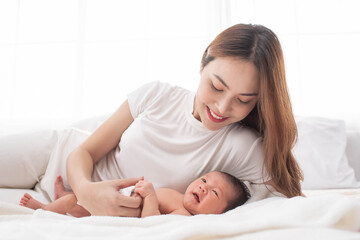 woman and new born boy relax. mother breast feeding baby. family at home. happy mother and baby. young mother holding her newborn child. mom nursing baby. mother and baby child on a white bed.