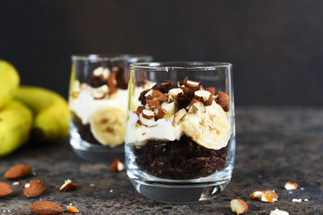 Dessert trifle with banana, chocolate biscuit and cream cheese.
