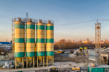 Cement storage silos are painted in yellow-green stripes.