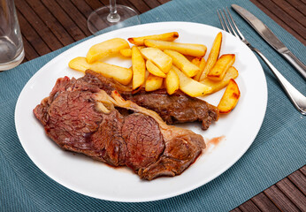 Appetizing beef entrecote with baked potatoes served at plate