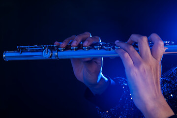 Close up of the hands of a young woman playing a silver flute © Andrea Tosi