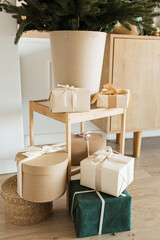 Homemade craft gift boxes with bow ties under Christmas tree. Merry Christmas / Happy New Year holidays celebration concept.