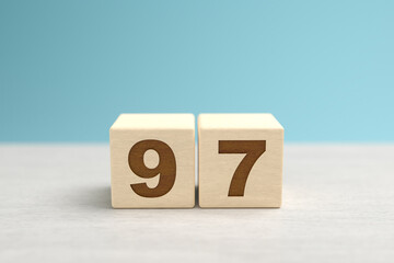 Wooden toy blocks forming the number 97.