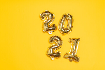New year 2021 foil balloons on a yellow background