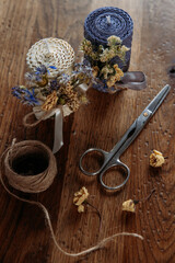 DIY decorative wax candles, scissors and twine on wooden table