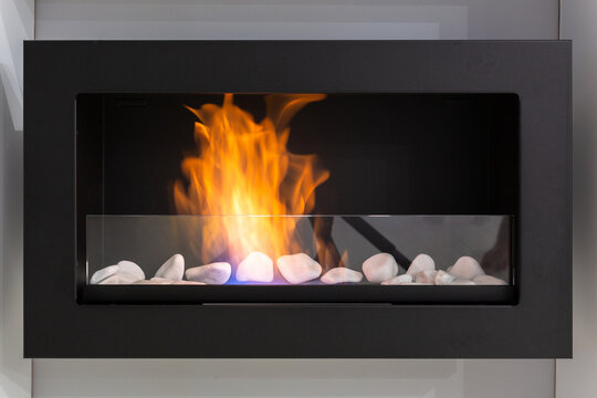 Fire in a bio fireplace working on ethanol fuel mounted on the wall.