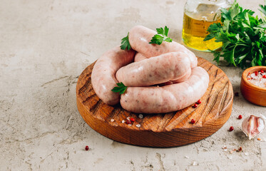 Raw chicken sausage for grilled on wooden cutting board with parsley.
