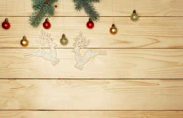 Small twigs fir tree lie on a light wooden wall background. Holiday