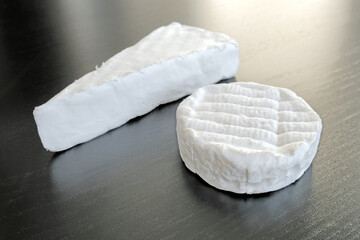 french cheese brie and camembert isolated on black wooden table background. Cuisine of france classic soft cheese. Natural color of diary product. Gourmet snack. Perspective top side closeup view