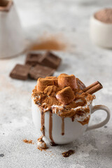Hot chocolate cocoa with whipped cream decorated with cinnamon and marshmallow on concrete background. Winter times drink concept