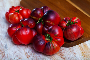 Fresh juicy organic Heirloom tomatoes on wooden table