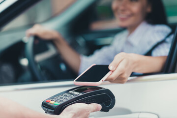 Close-up cropped view of her she attractive blurred content cheerful lady consumer riding sitting in car paying virtual money cash using device gadget buying goods web connection transaction