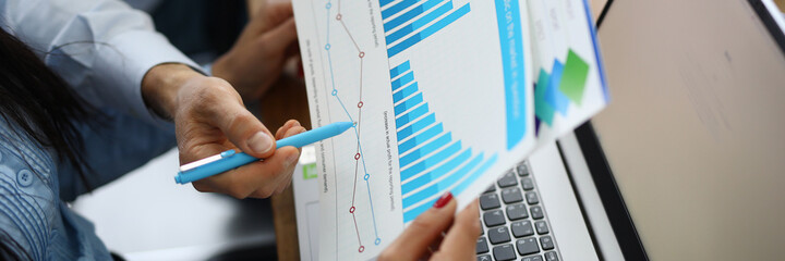Female and male hand holding graph with financial performance at the workplace. Research and forecasting of commercial indicators in business concept