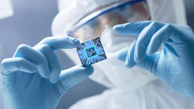Futuristic Technology Concept: Engineer in Sterile Coverall Holds Computer Microchip with Gloves and Examines it. CPU Processor Digitalization with Data Lines Form Artificial Intelligence Symbol