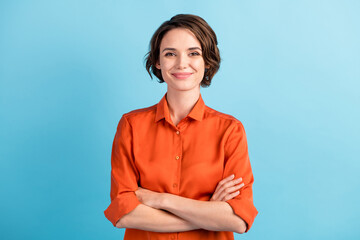 Photo of attractive charming lady cute bobbed hairdo arms crossed self-confident person worker friendly smile good mood wear orange office shirt isolated blue color background - obrazy, fototapety, plakaty